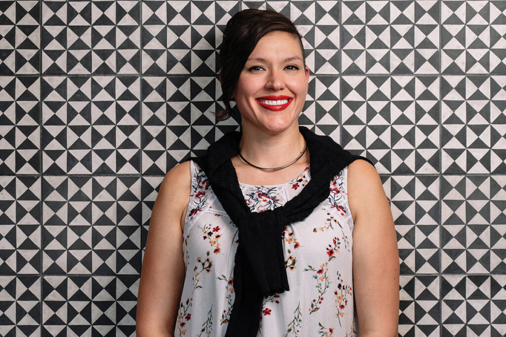 Michelle Raza, brunette woman in front of black and white background
