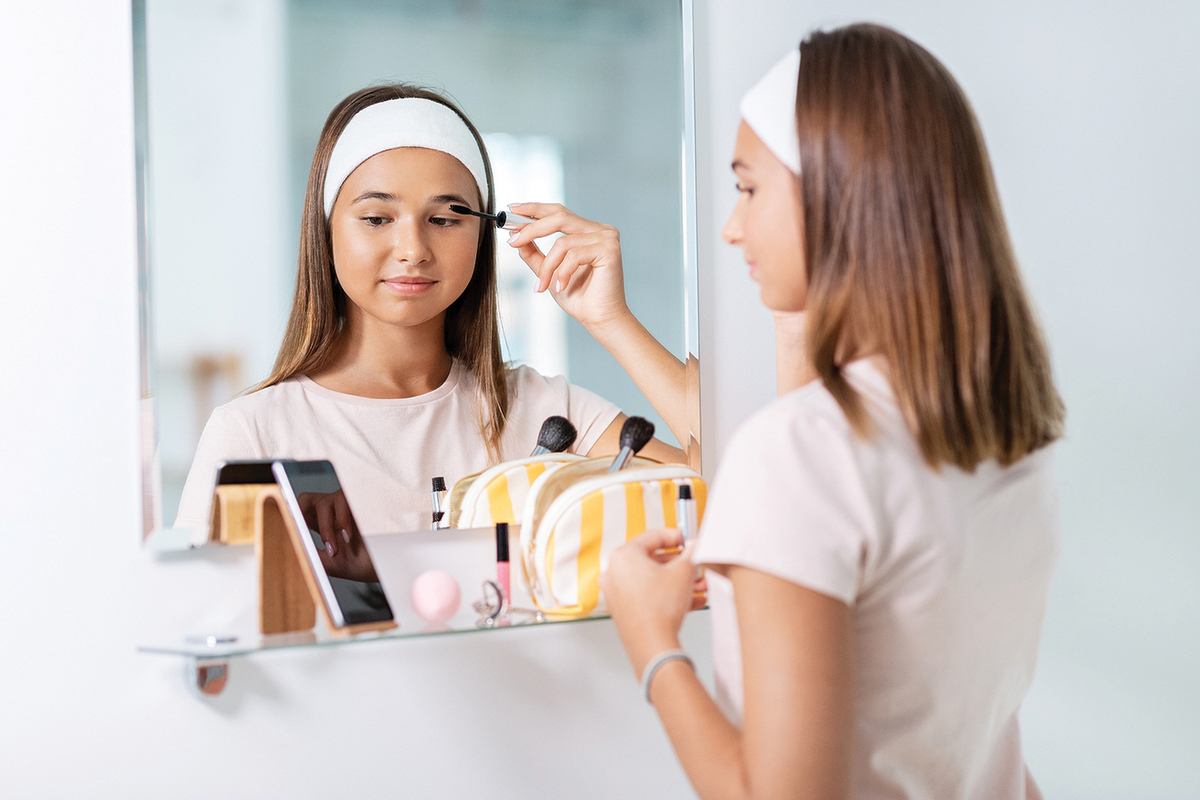 beauty, make up and cosmetics concept teenage girl applying